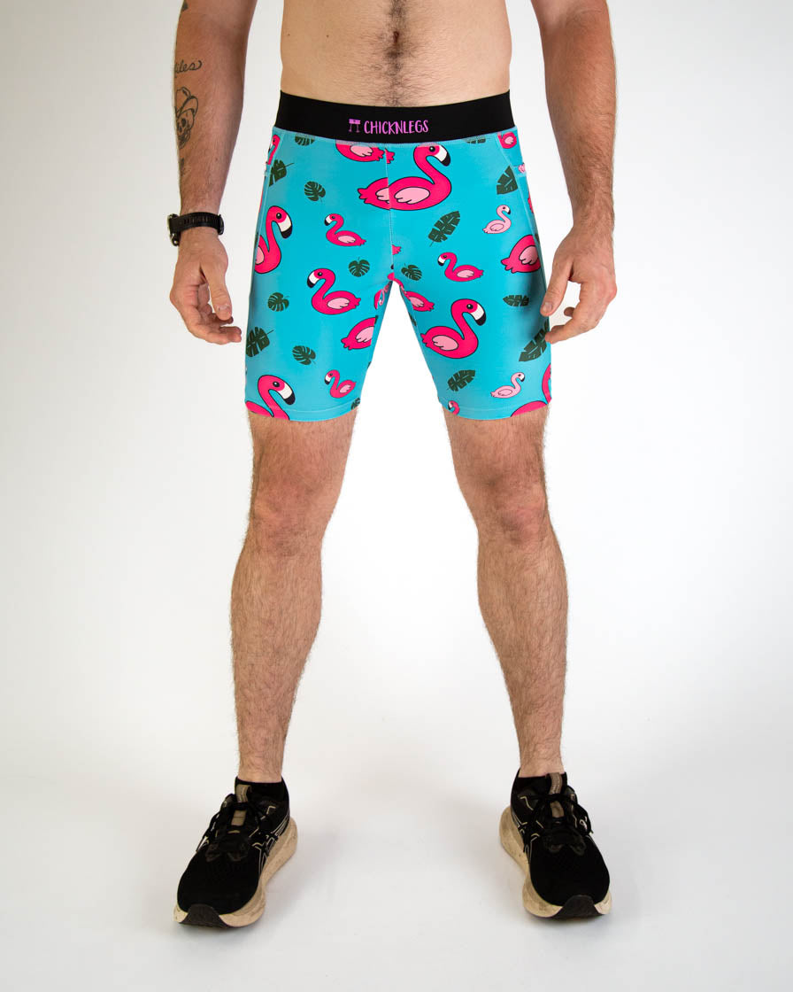 Man wearing turquoise blue half tights with pink flamingo and tropical leaf pattern