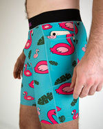 Men's teal compression shorts with pink flamingo and tropical leaf pattern