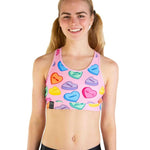 Pink sports bra with colorful candy hearts pattern featuring text like 'THIRSTY' and 'MOODS'