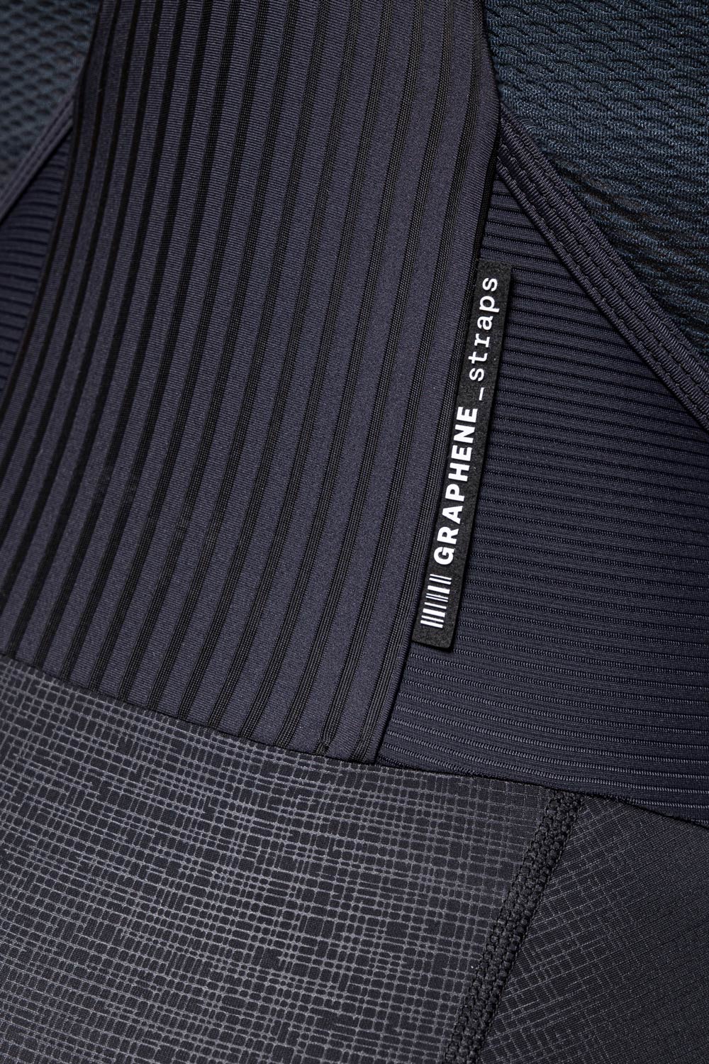 Close-up detail of Gobik Absolute K9 women's cycling culotte showing graphene straps label and multi-texture black fabric panels