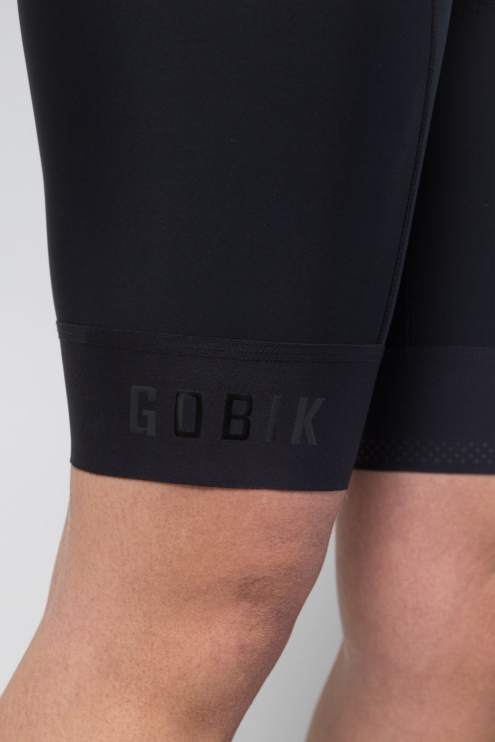 Close-up of Gobik branded leg gripper band on black bib short lower hem
