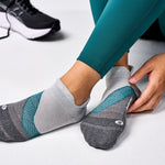Grey Feetures Elite Light Cushion Tab socks with teal accents on feet