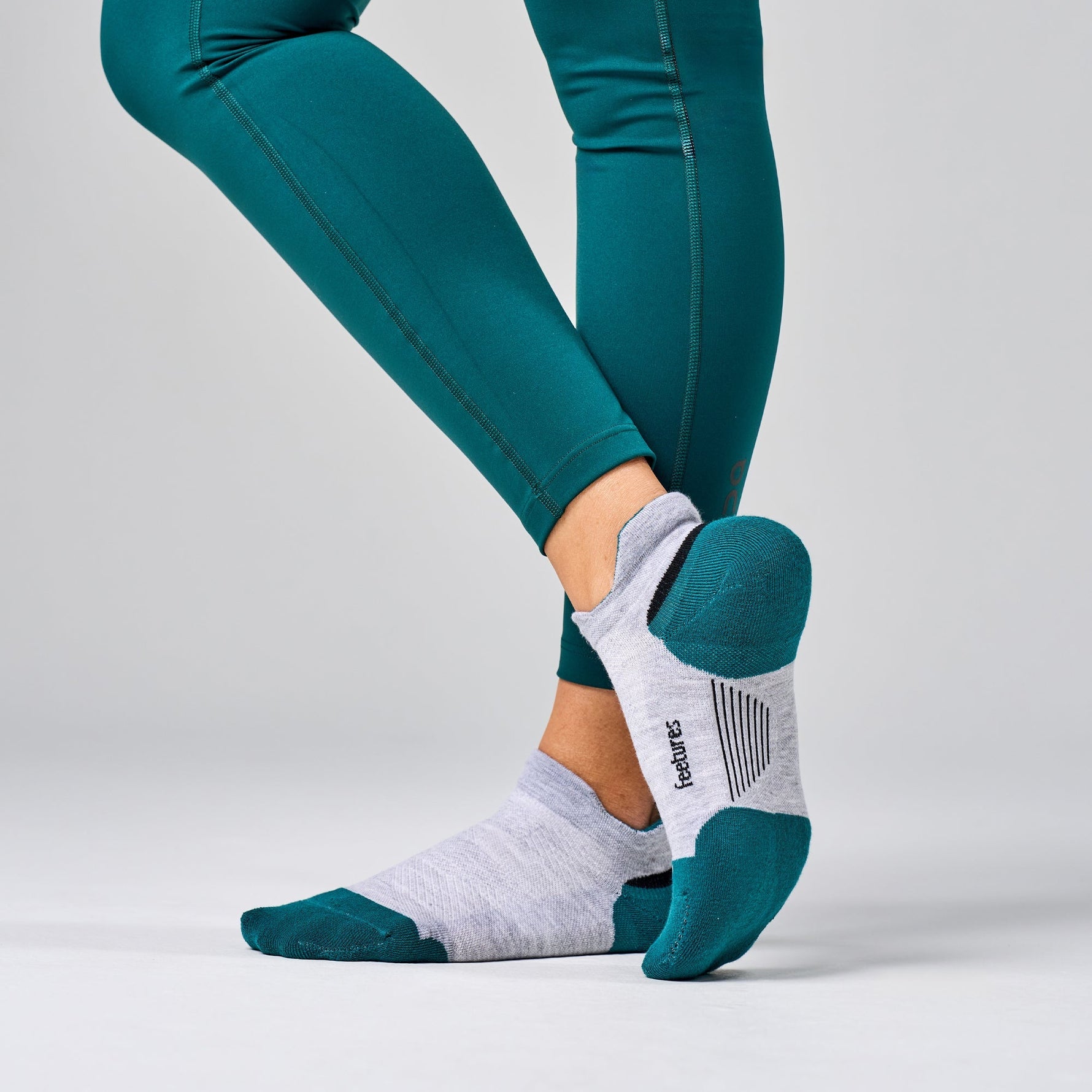 Feetures Elite Max Cushion Tab socks in light grey with teal heel and toe