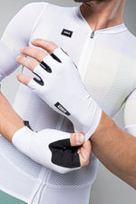 White Gobik cycling gloves with black grip details on cyclist's hands