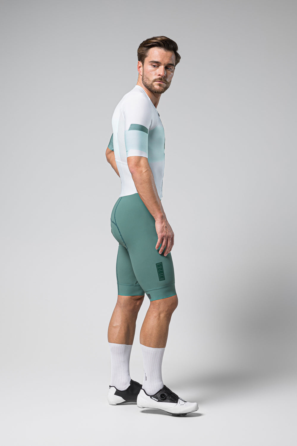 Male model wearing Gobik Brooklyn Aerosuit in white and sage green colorway