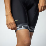 Close-up of black women's cycling bibshort leg with striped cuff and PRR logo