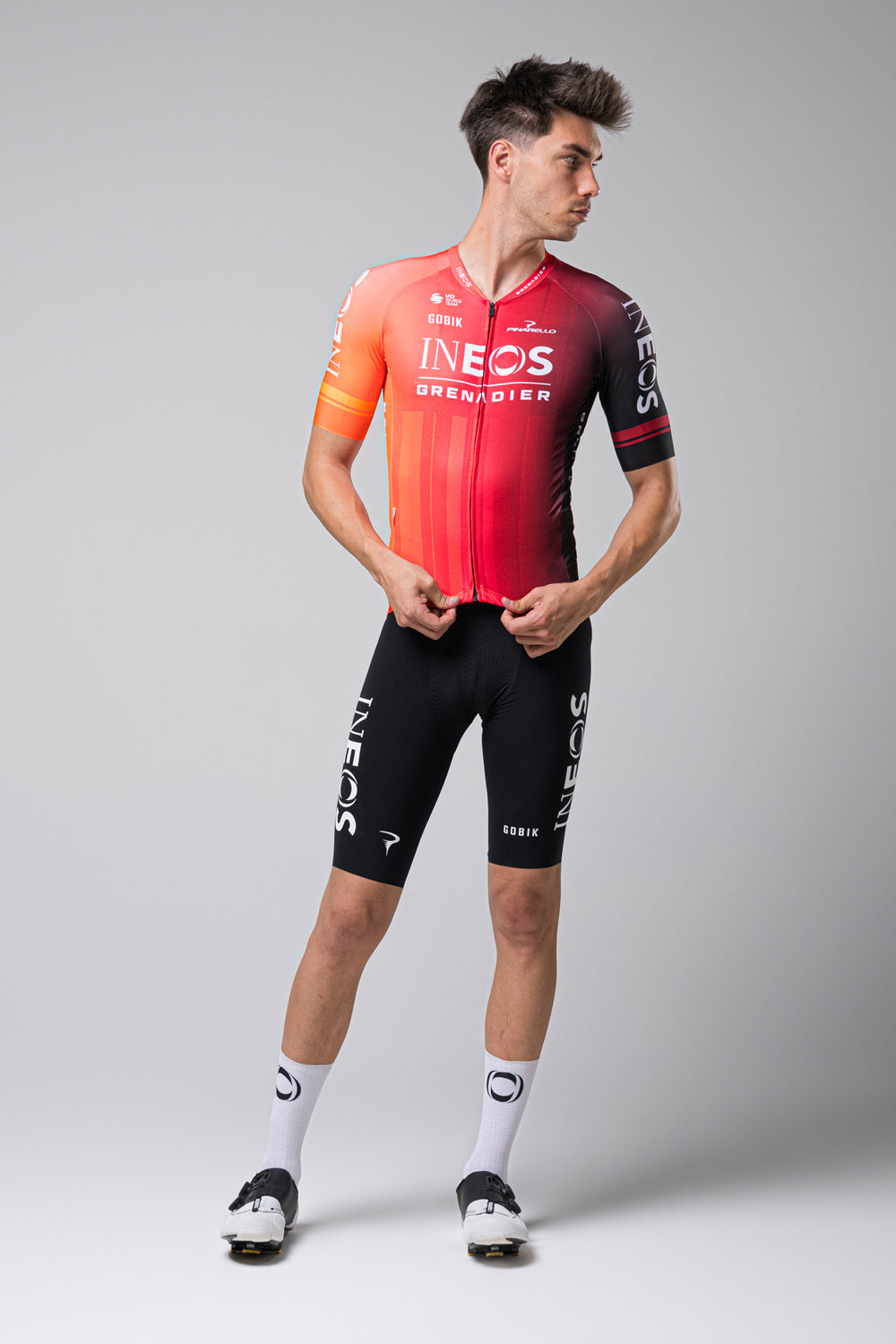 Male cyclist wearing Gobik INEOS Grenadiers red gradient cycling jersey with black shorts