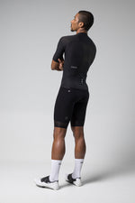 Male cyclist wearing black Gobik Phantom jersey and shorts in studio setting