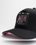 Close-up detail of Wrld Tags Miami MIA rubber patch on black snapback hat with pink lining