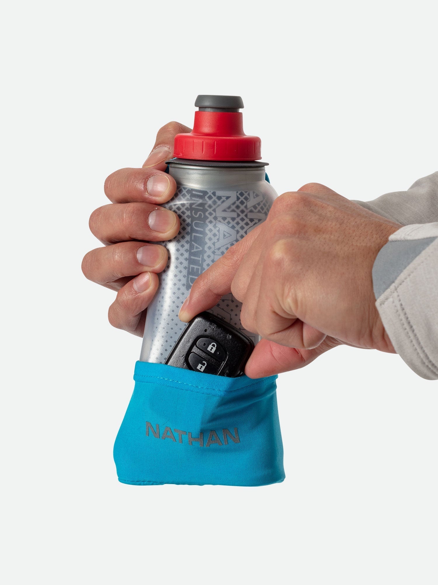 Nathan handheld water bottle with blue sleeve being held showing phone storage pocket