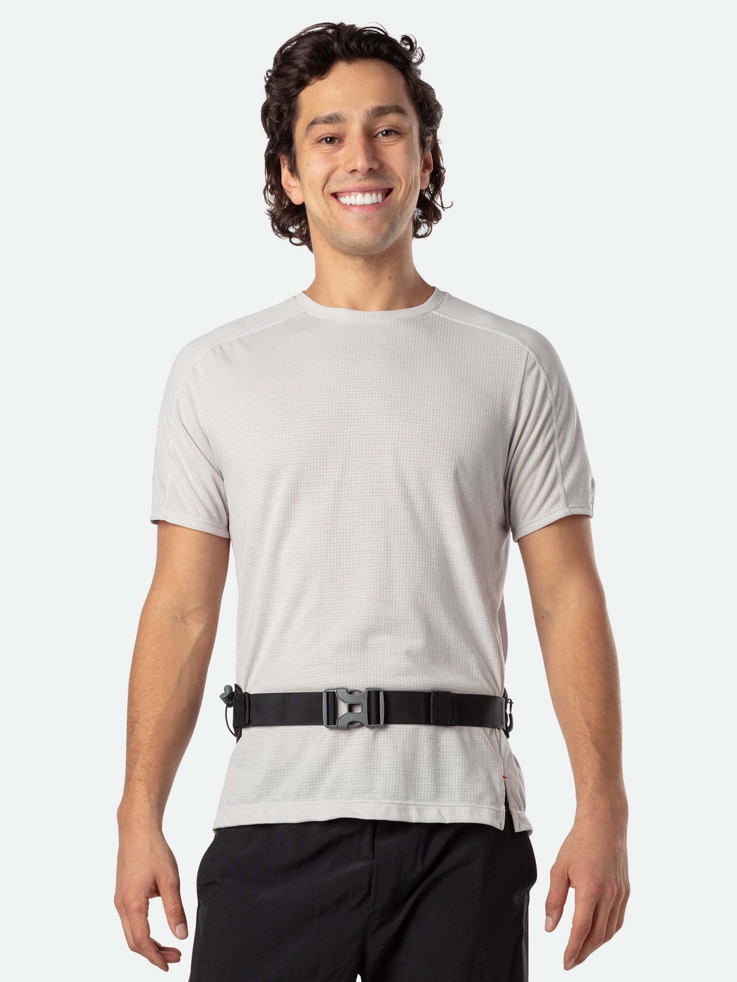 Man wearing Nathan Peak Hydration Waist Pack in black around waist