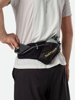 Person wearing Nathan Peak Hydration Waist Pack in black with gold accents around waist