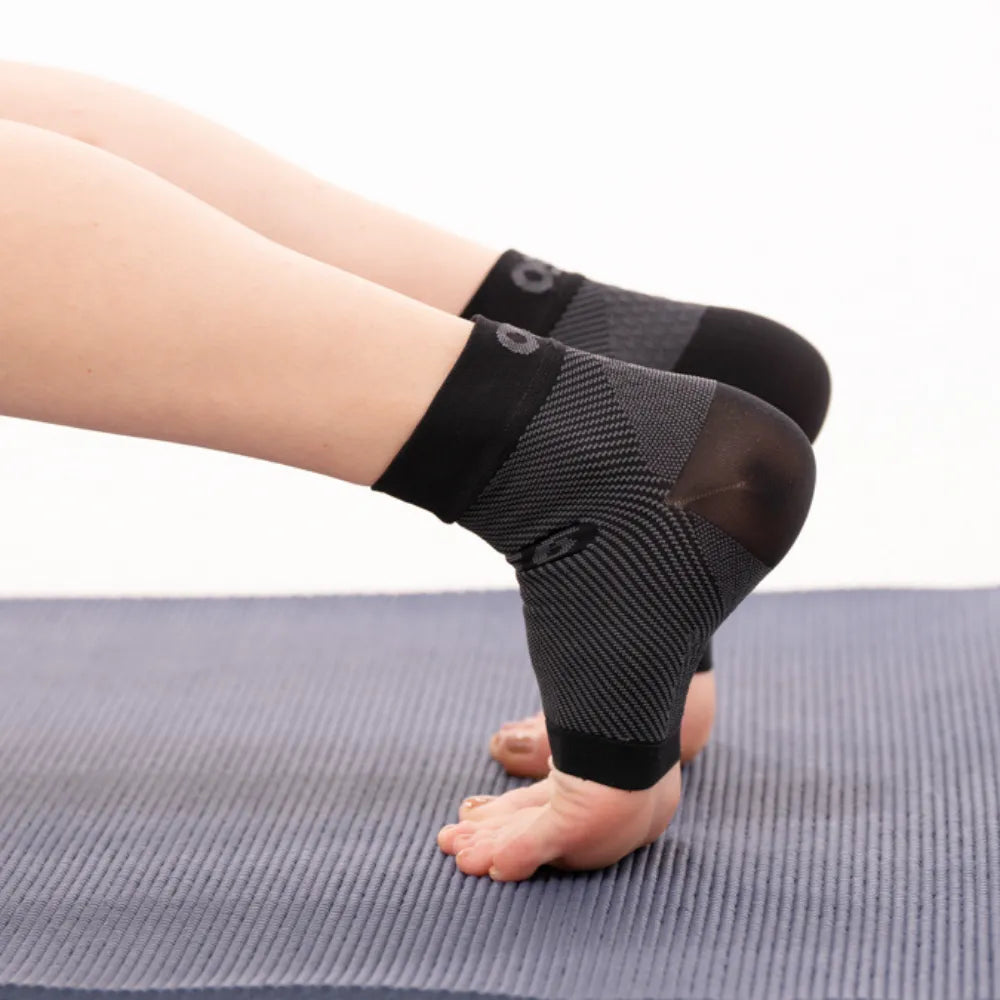 OS1ST FS6 Performance Foot Sleeves in black worn on feet during exercise