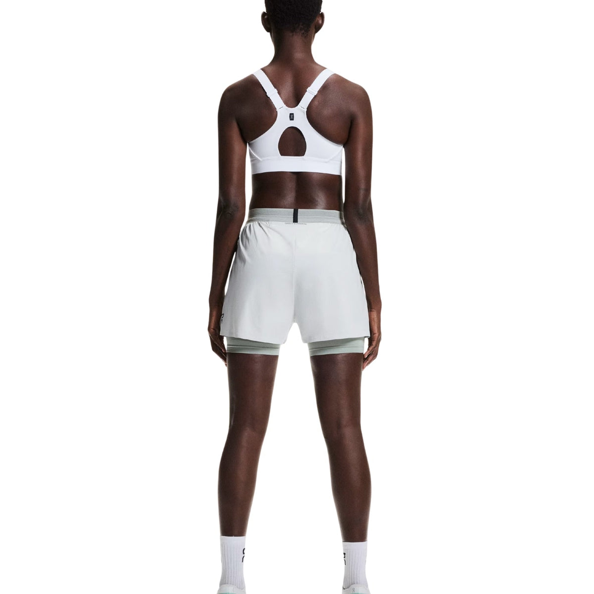 On Running Performance Bra in white showing keyhole back design, rear view on model