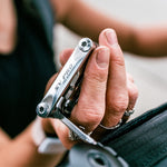 Hand holding Lezyne SV Pro CNC Stainless multi tool in silver finish