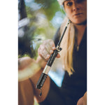 Woman cyclist holding Lezyne Pressure Drive S mini bike pump outdoors in forest
