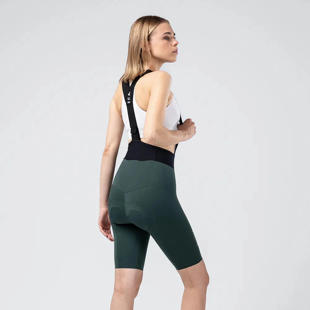Woman wearing Gobik X Bib Short in dark green, professional studio photo