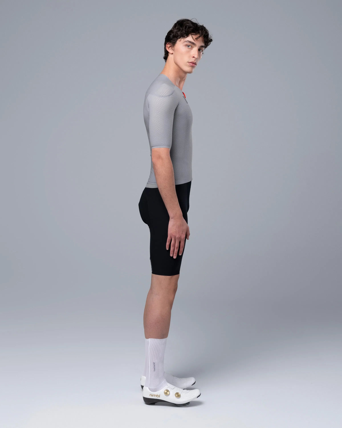 Male model wearing TheOneOff Krypton Short Sleeve Jersey Future Gray with black cycling shorts, side view