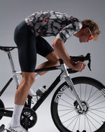 Male cyclist riding road bike wearing TheOneOff Krypton jersey in grey digital camo pattern