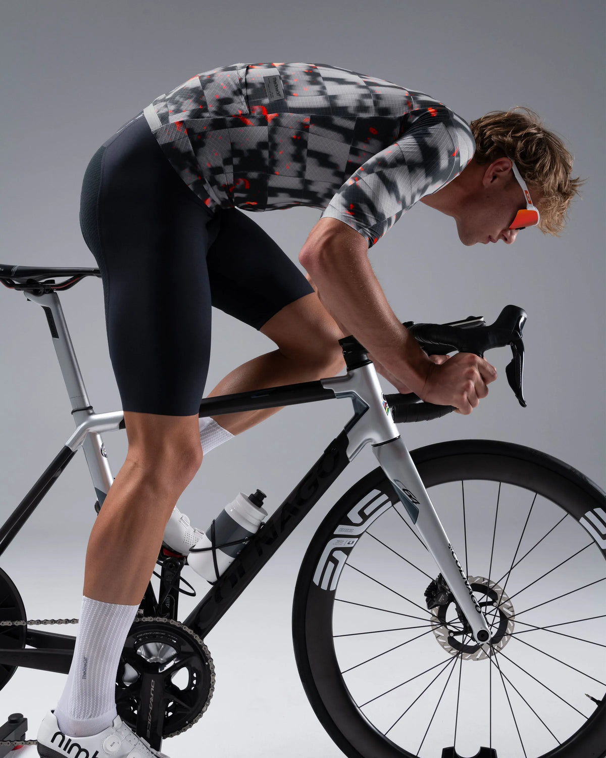 Male cyclist riding road bike wearing TheOneOff Krypton jersey in grey digital camo pattern