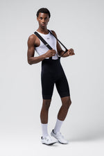 Male model wearing black Gobik cycling bib shorts with white base layer