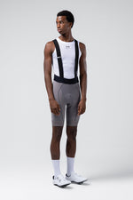 Male model wearing Gobik Absolute Compact bib shorts in gray Kettle with white base layer, front view
