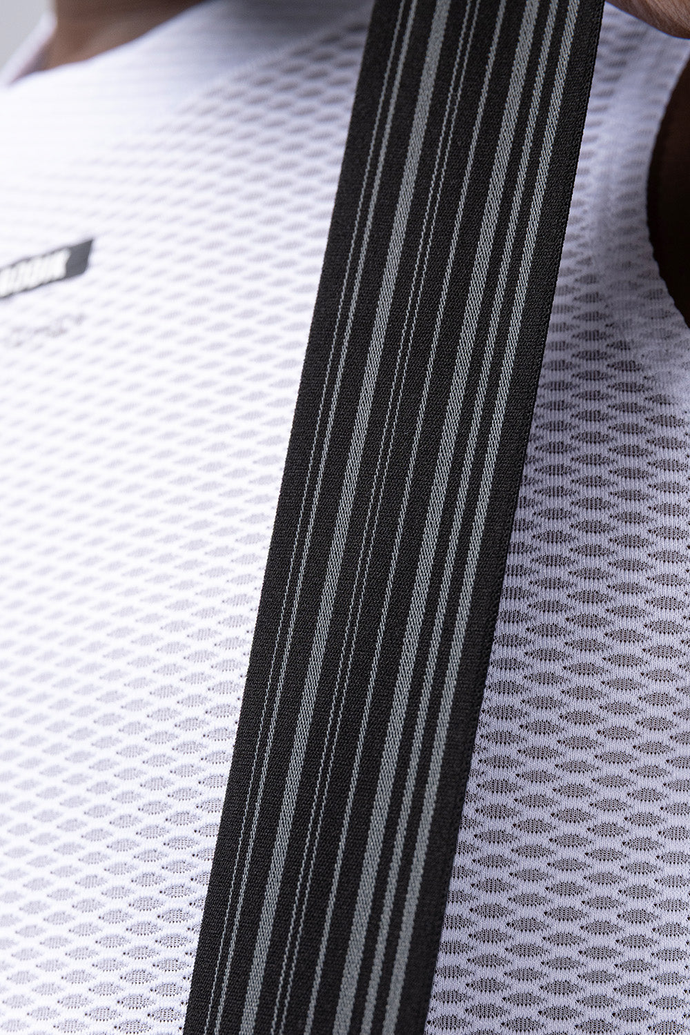 Close-up detail of Gobik bib short suspender strap showing woven texture and gray stripe pattern