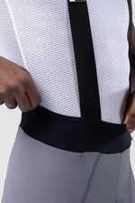 Close-up of Gobik bib short waistband area showing black elastic waist and gray Kettle shorts fabric