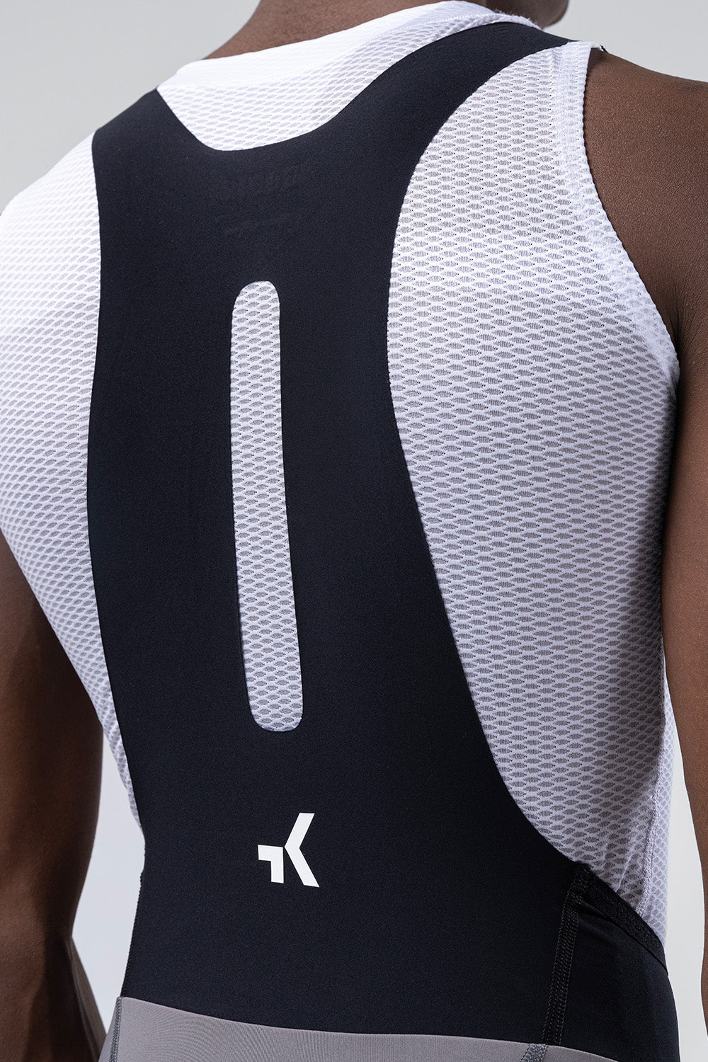 Close-up detail of Gobik bib straps showing mesh back panel and brand logo on male model
