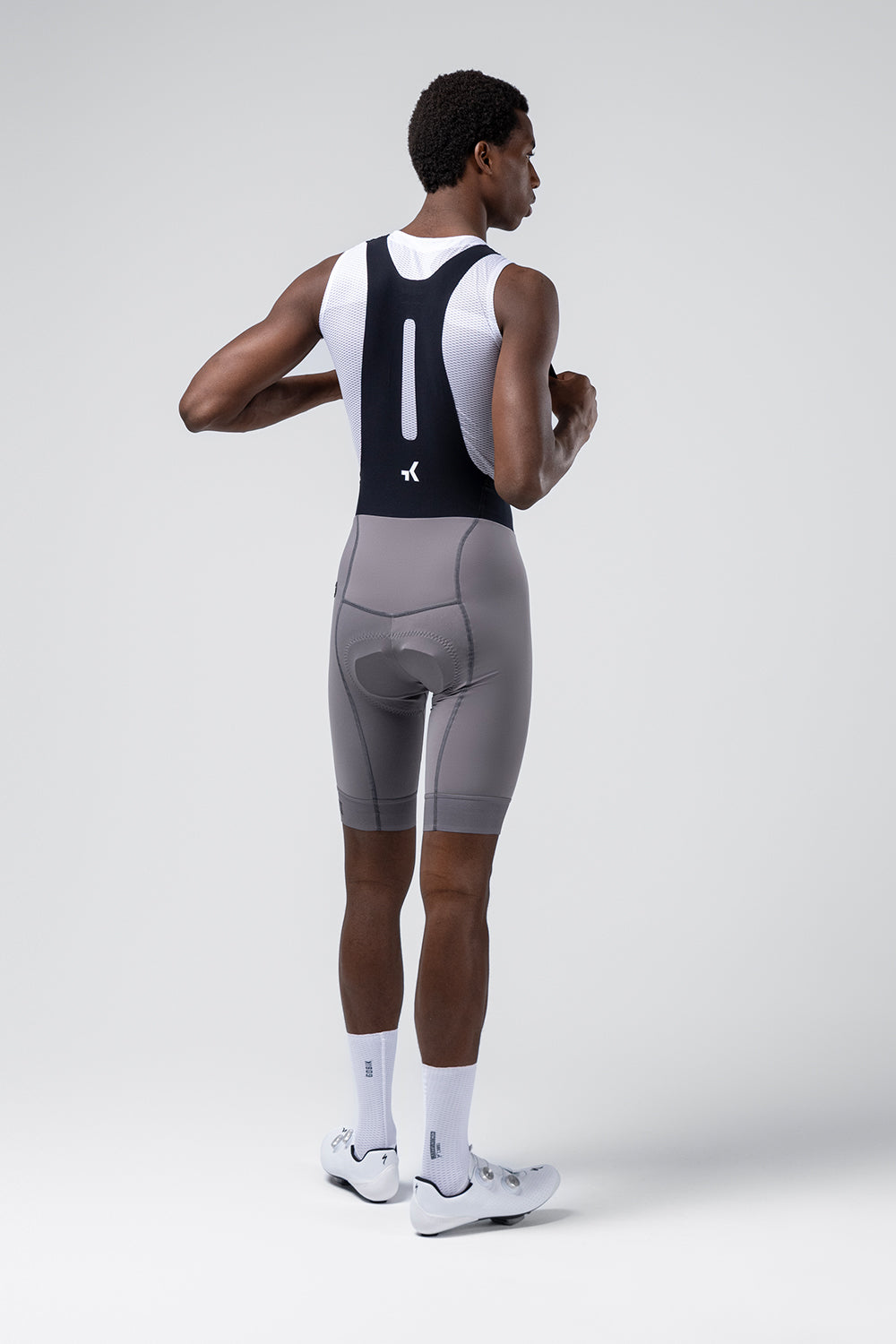 Man wearing gray Gobik Absolute Compact 7.0 cycling bib shorts with white tank top