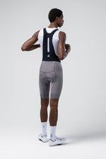 Gobik Absolute Compact 7.0 bib shorts in Kettle gray worn by male cyclist, rear view