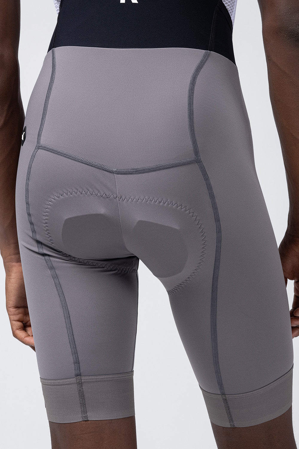 Close-up rear view of Gobik Absolute Compact bib shorts showing padded chamois in gray Kettle color