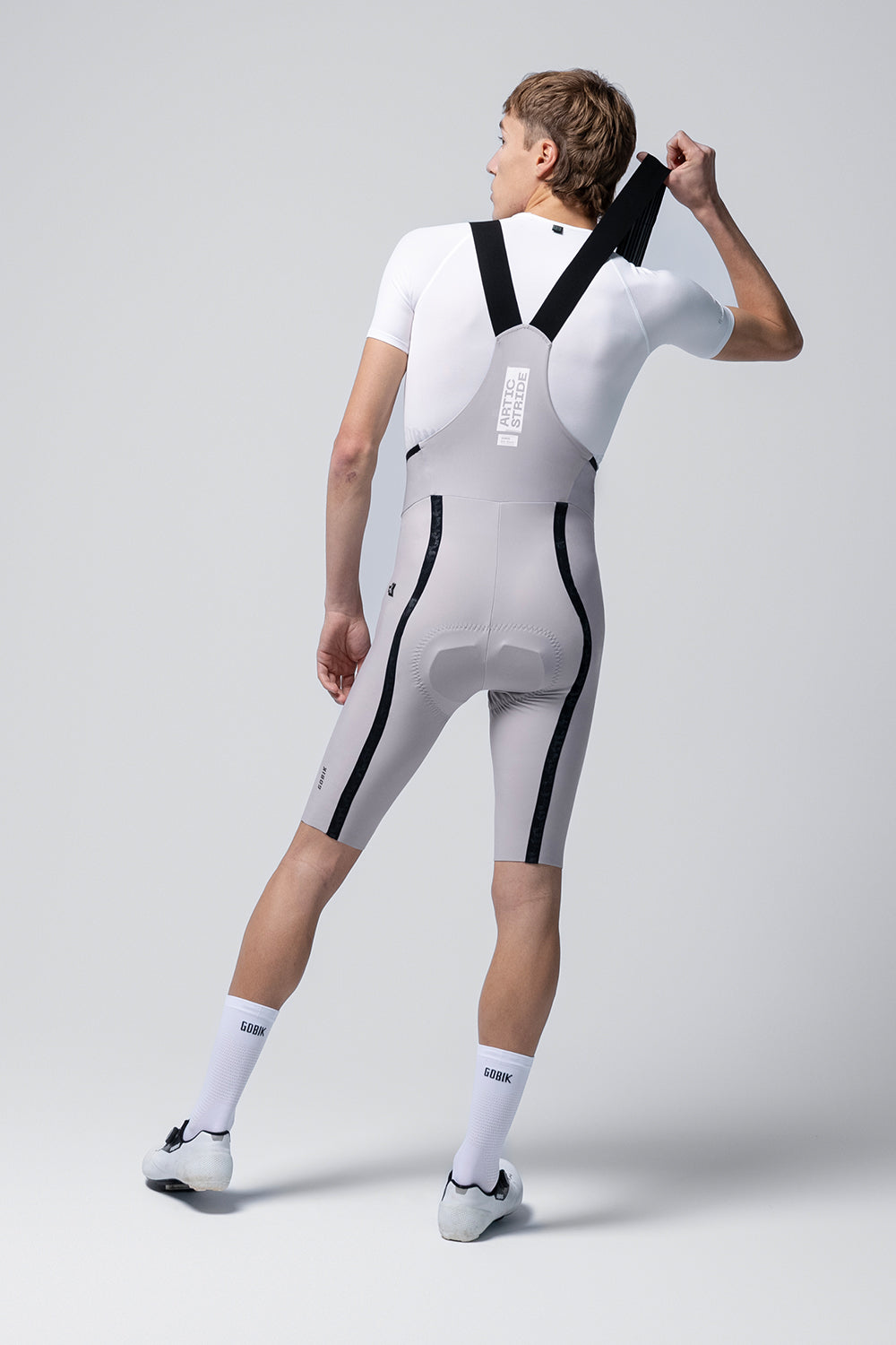 Rear view of Gobik Artic Stride men's bib shorts in tapioca showing chamois pad and black straps