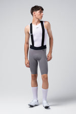 Male cyclist wearing gray Gobik X bib shorts with white base layer and socks