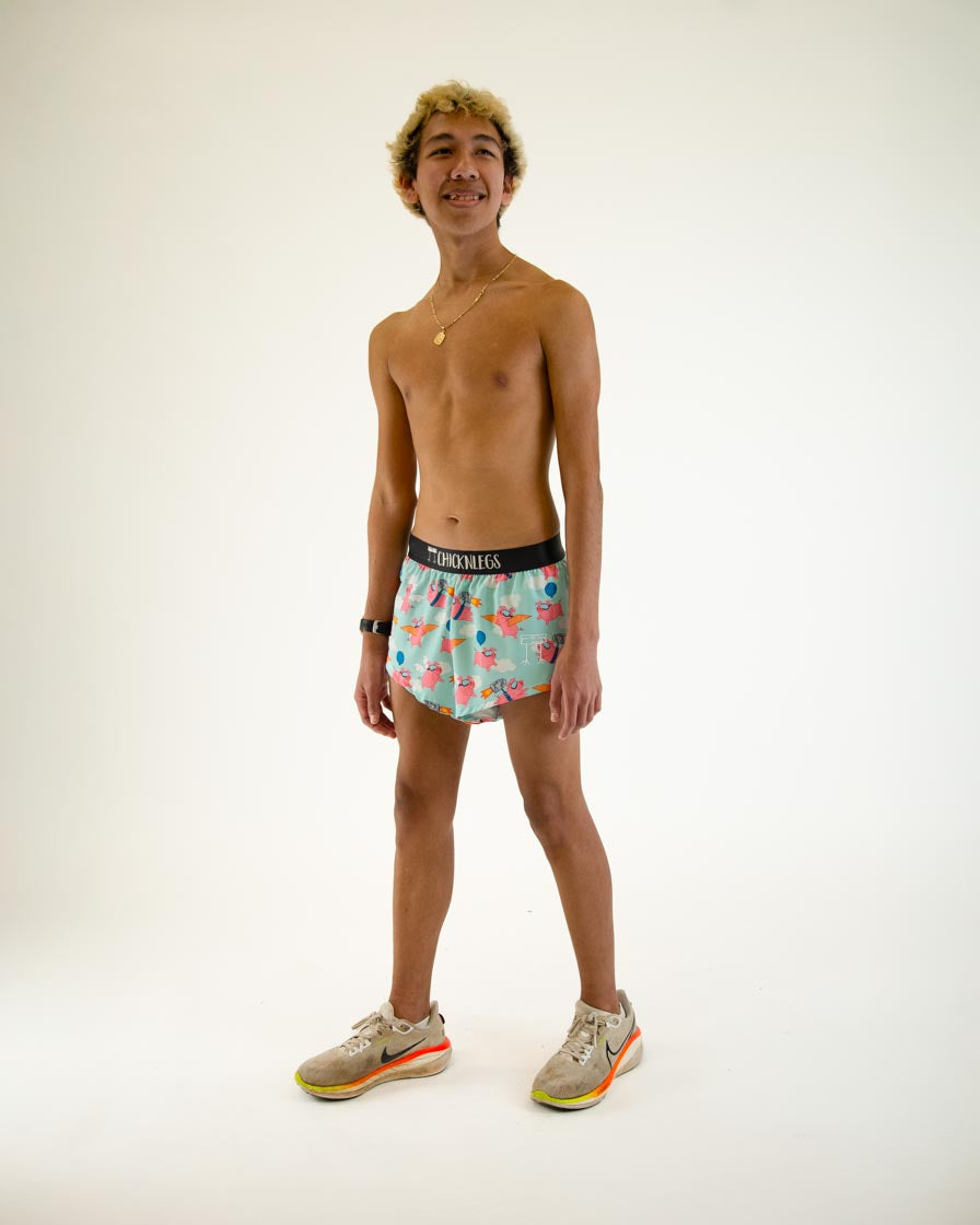 Man wearing ChicknLegs Flying Pigs split running shorts in turquoise with pink pig pattern