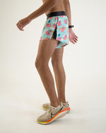 Man wearing ChicknLegs flying pigs pattern running shorts with split design
