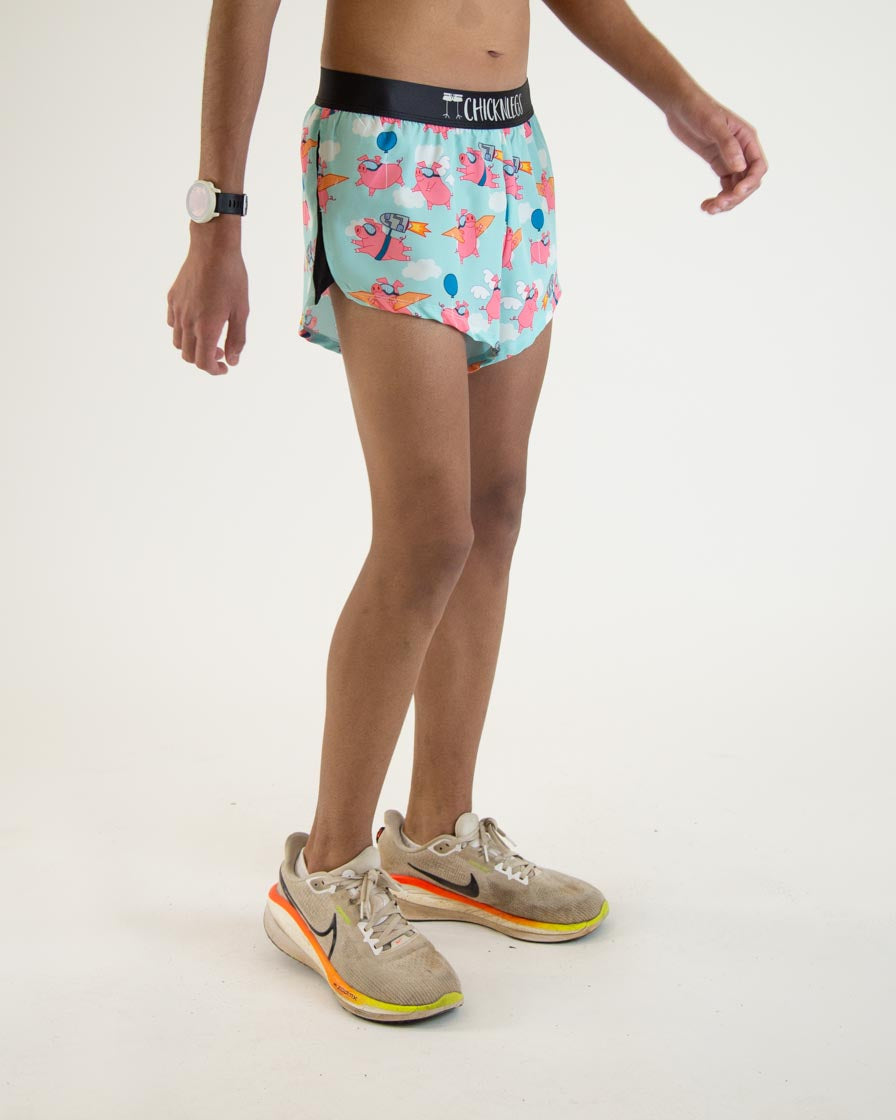 ChicknLegs men's running shorts with pink flying pig pattern on light blue background