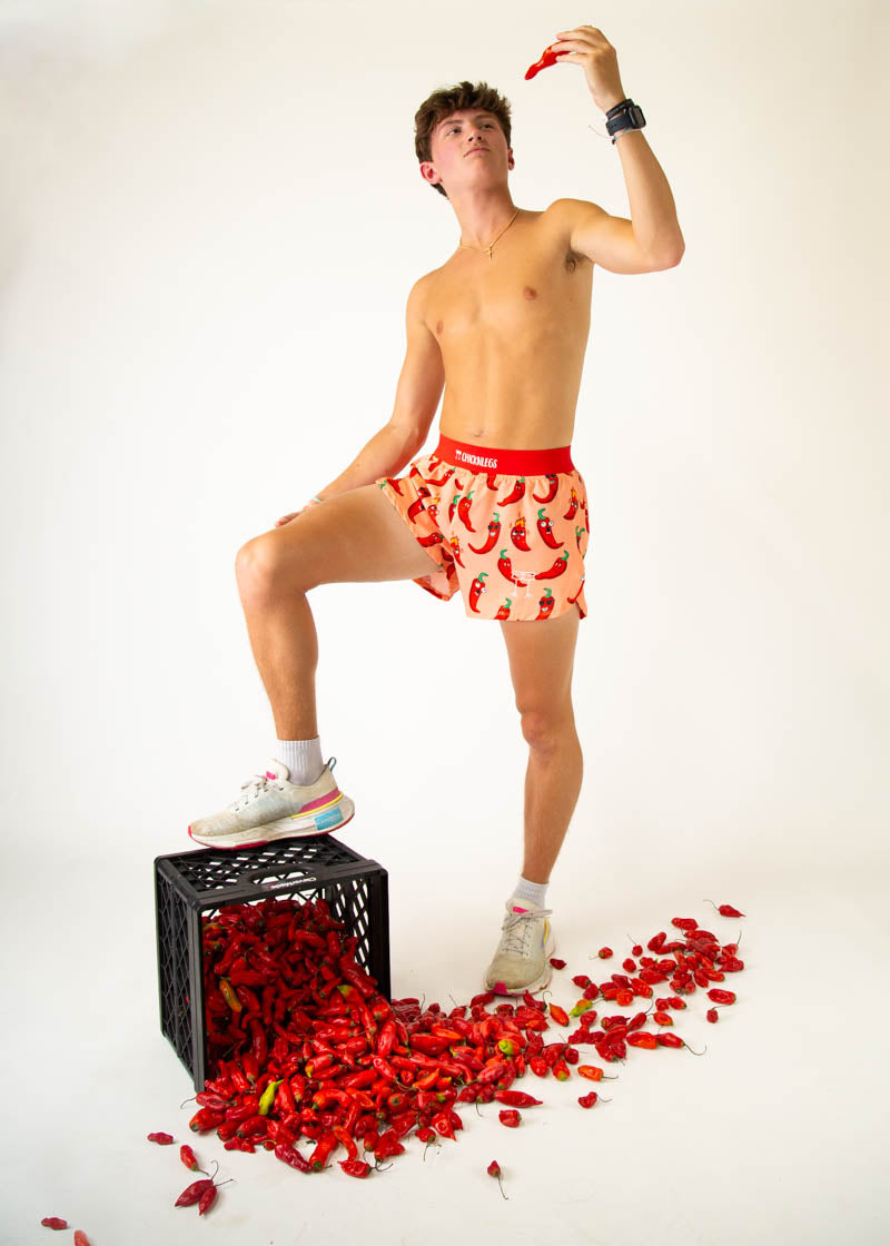 Man wearing ChicknLegs chili pepper print shorts in studio pose