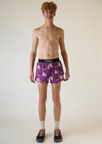 Man wearing purple ChicknLegs shorts with chocolate cow pattern