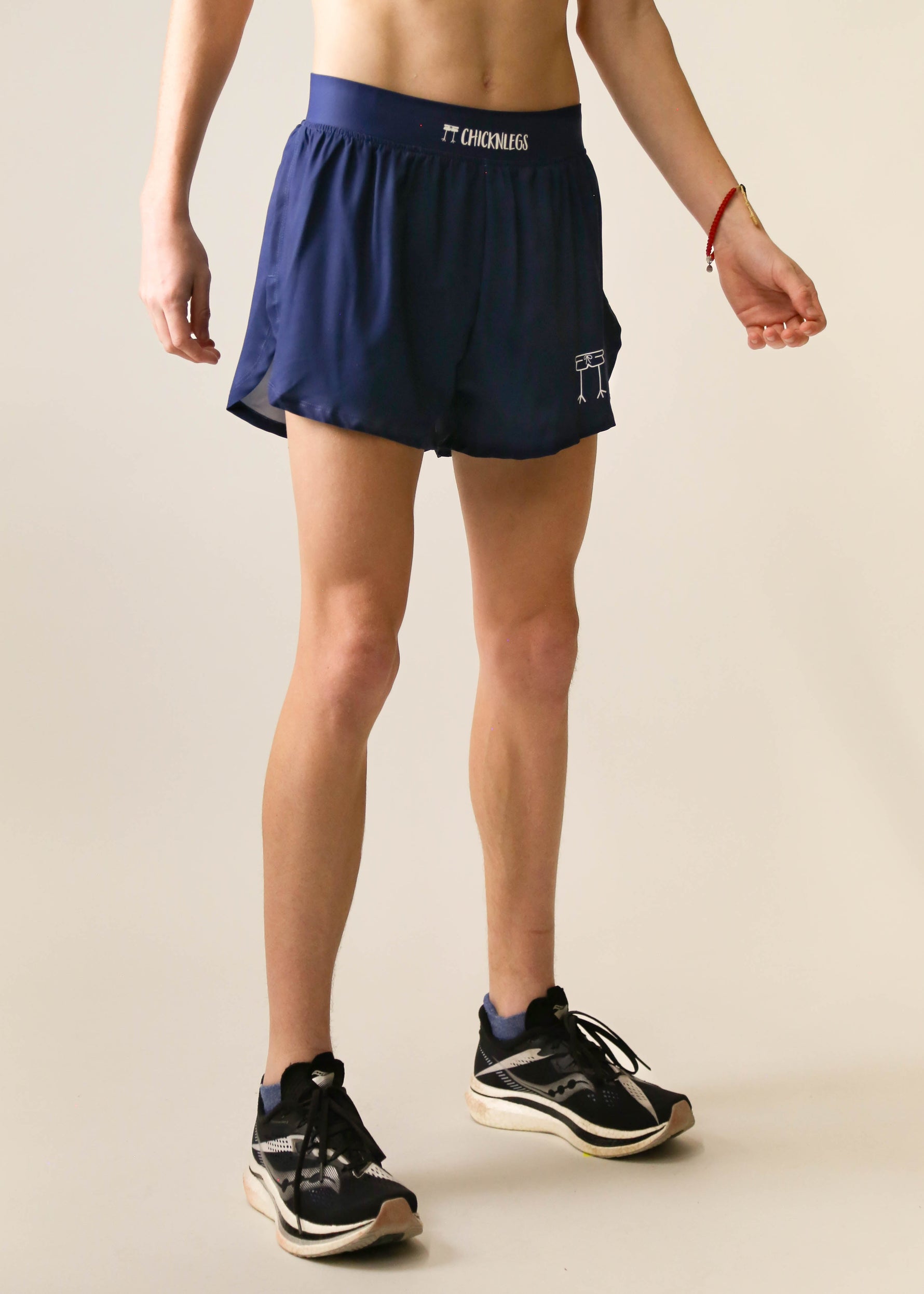ChicknLegs 4-inch navy blue half split running shorts on female model with sneakers