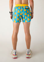 Man wearing blue shorts with yellow rubber duck pattern, rear view