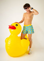 Man wearing ChicknLegs rubber ducky patterned shorts posing with inflatable yellow duck