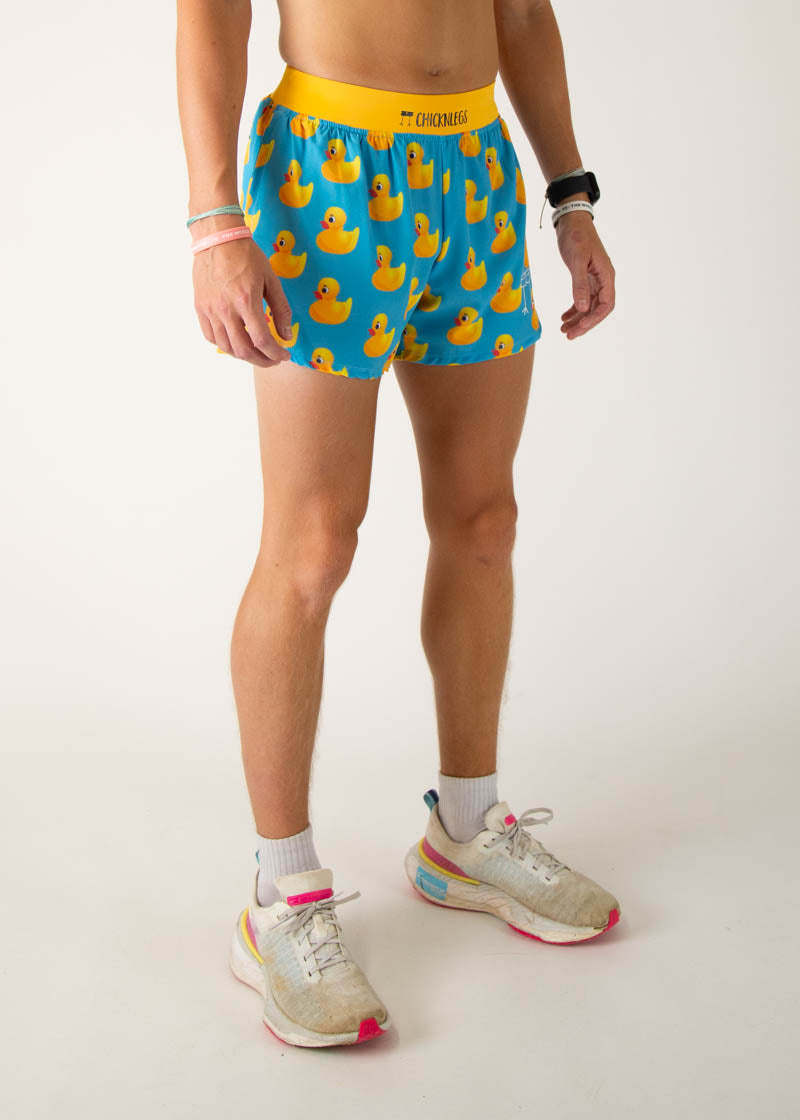 Man wearing ChicknLegs blue shorts with yellow rubber duck pattern and yellow waistband