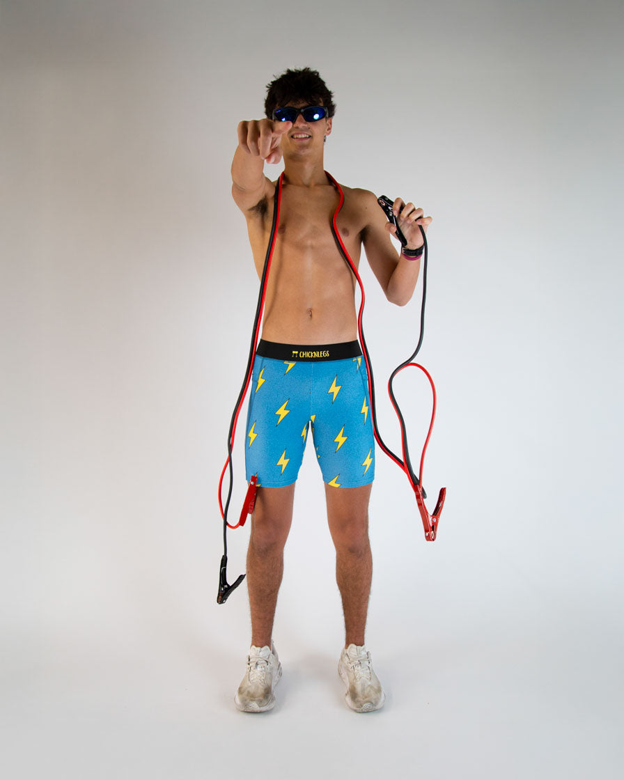 Man wearing ChicknLegs blue shorts with yellow lightning bolt pattern on white background