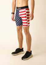 Man wearing ChicknLegs USA flag pattern compression shorts with athletic shoes