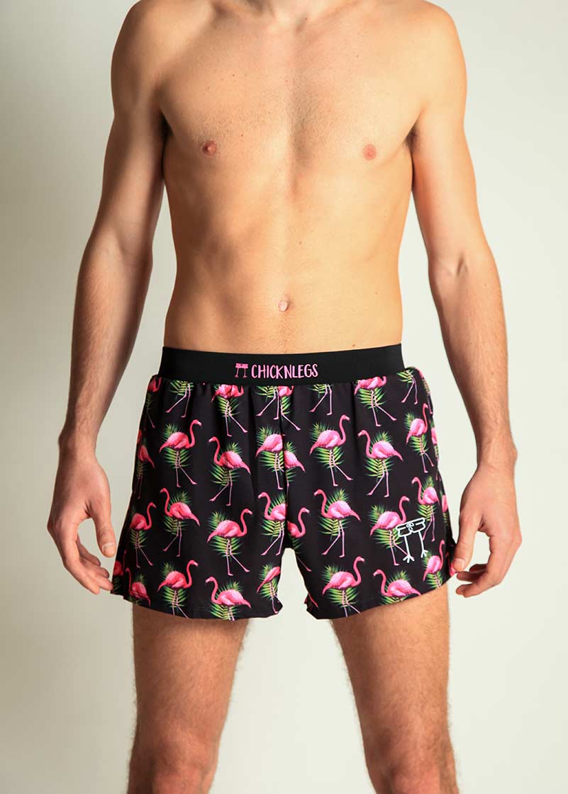 Male model wearing ChicknLegs black flamingo print 4-inch half split running shorts