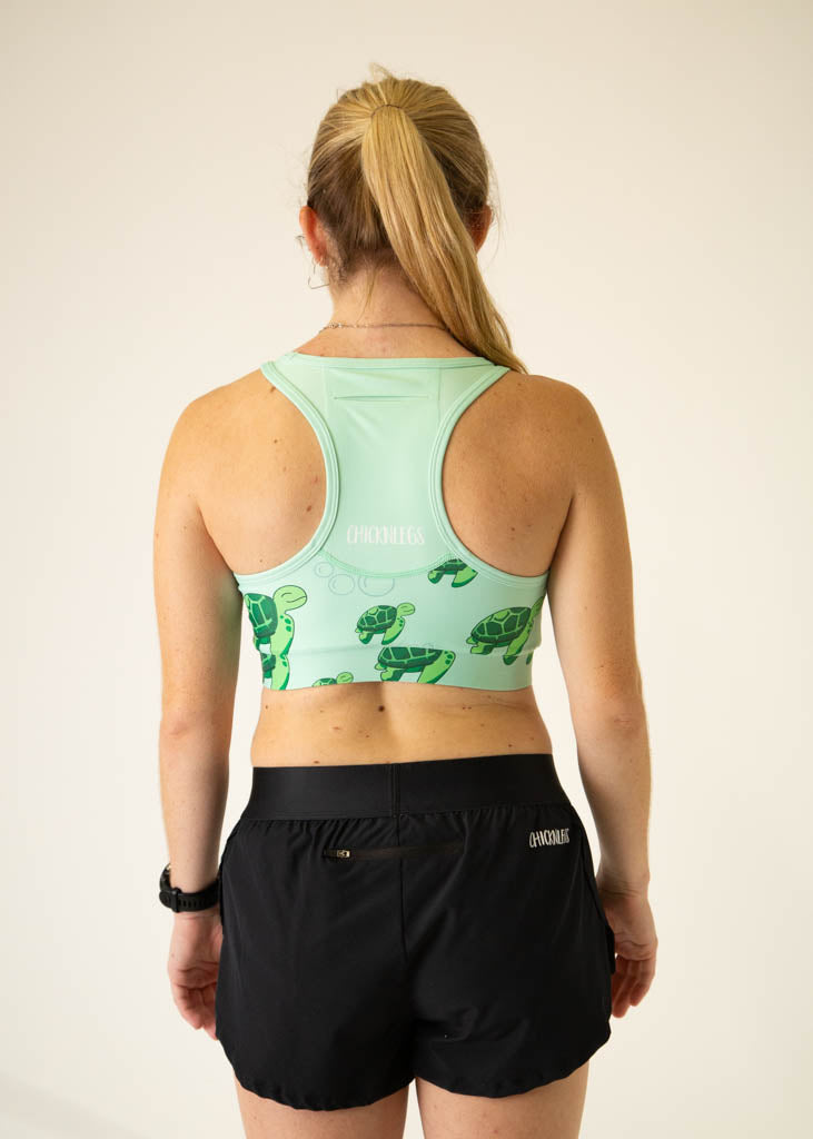 ChicknLegs mint green sports bra with sea turtle print, back view on model