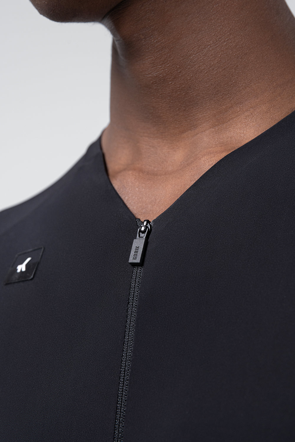 Black Gobik cycling jersey with zipper detail and clean studio lighting