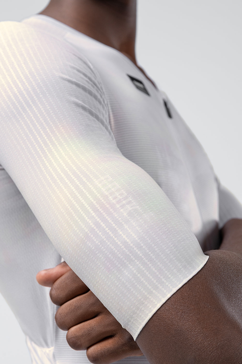 Close-up of Gobik Aerosuit Madison sleeve showing iridescent white Crisp fabric texture and ribbed pattern