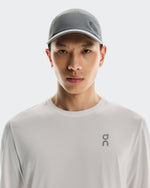 Asian male model wearing grey On Lightweight Unisex Cap and white athletic shirt